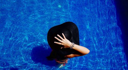 High angle view of woman wearing sun hat in swimming pool