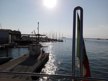 Sailboats moored at harbor against clear sky