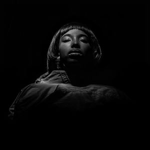 Close-up of young woman with eyes closed against black background