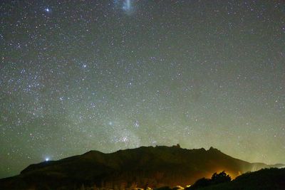 Mountain against starry sky at night