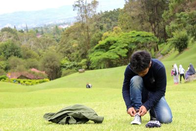 Man tying shoelace at golf course