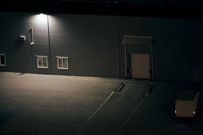 Empty parking lot against building at night