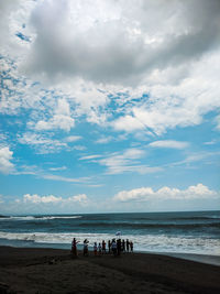 People on beach against sky