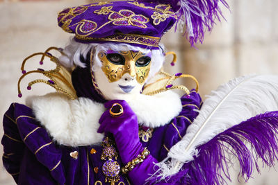 Person looking away while wearing purple costume and mask
