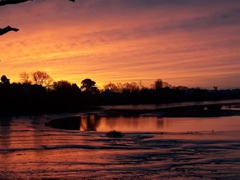 Scenic view of lake against romantic sky at sunset