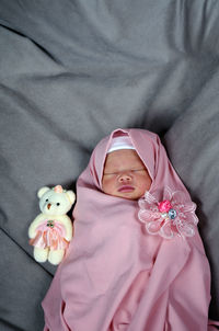 Directly above shot of baby girl lying on bed at home