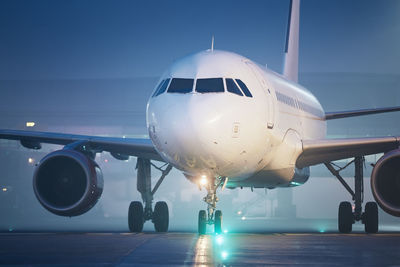 Front view of airplane at airport at night. plane during taxiing to runway for take off.