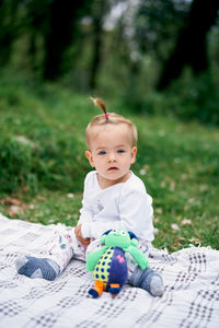 Cute boy sitting on grass