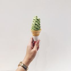 Midsection of woman holding ice cream against white background