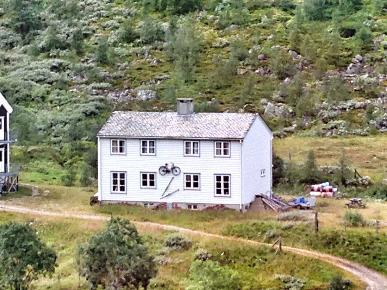 grass, building exterior, architecture, built structure, field, tree, house, transportation, green color, landscape, nature, day, mountain, growth, plant, rural scene, grassy, mode of transport, outdoors, tranquility