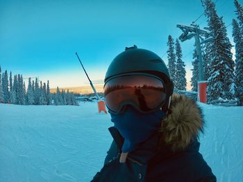 Portrait of man wearing helmet and eyewear in winter during sunset