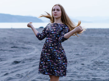 Portrait of beautiful woman standing against sea