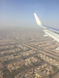 Cropped image of airplane flying over cityscape