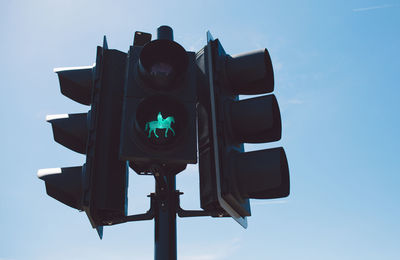 Low angle view of road sign against clear blue sky