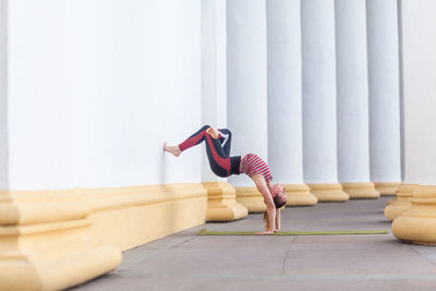 Rear view of woman exercising on floor