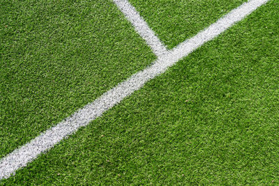 Green artificial grass turf soccer football field background with white lines