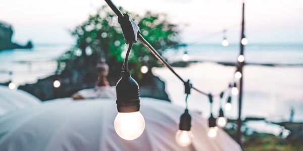 Close-up of light bulb hanging by sea