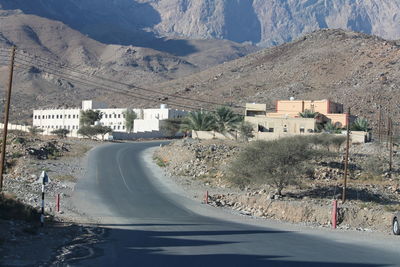 Road by mountains against sky