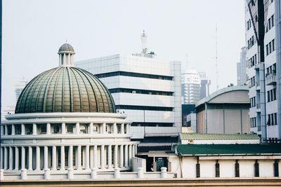 Buildings in city against clear sky