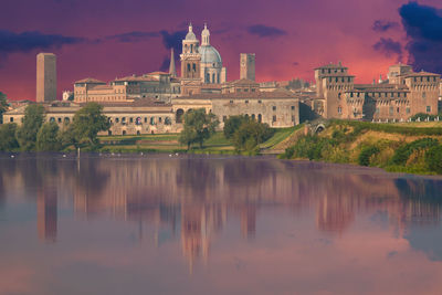 View of the city of mantua at sunset reflected on the middle lake on the mincio river