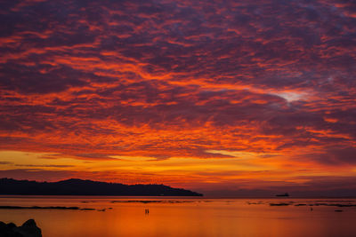 Scenic view of sea against dramatic sky during sunset