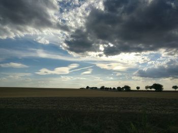 Scenic view of field against cloudy sky