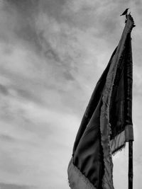 Low angle view of flags hanging on pole against sky