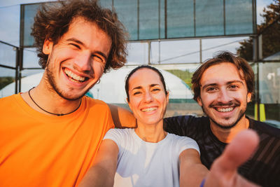 Portrait of smiling friends against wall