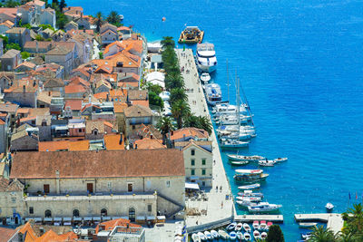 High angle view of town by sea against blue sky