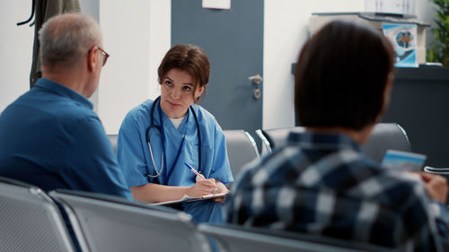 Doctor discussing with patient in waiting room at hospital