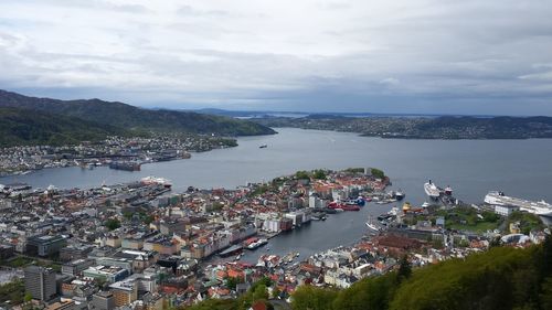 High angle view of city by sea against sky