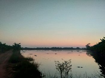 Scenic view of lake against clear sky during sunset