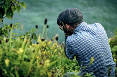 Rear view of man sitting amidst plants