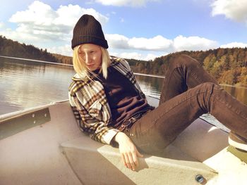 Woman sitting on beach against sky