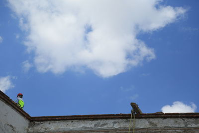 Low angle view of man against blue sky