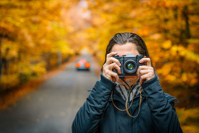 Photographer on autumn forest road