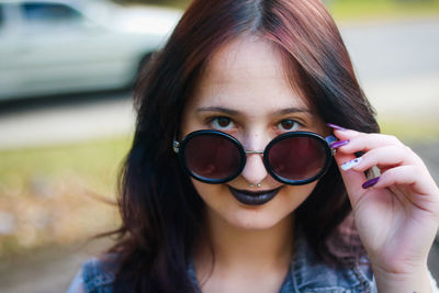 Close-up portrait of young woman wearing sunglasses