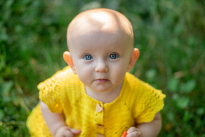 Portrait of cute baby boy standing on field