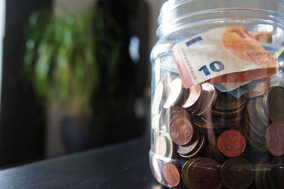 Close-up of currency in jar on table