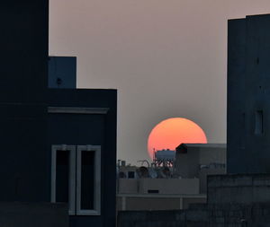 People standing by building against sky during sunset