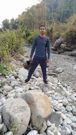 Full length of young man standing on rocks