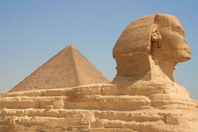 Great sphinx and pyramid against clear sky
