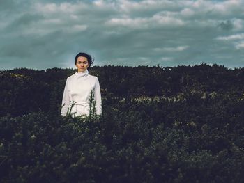 Portrait of woman standing on field against sky