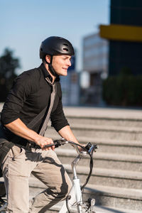 Young man riding bicycle on city