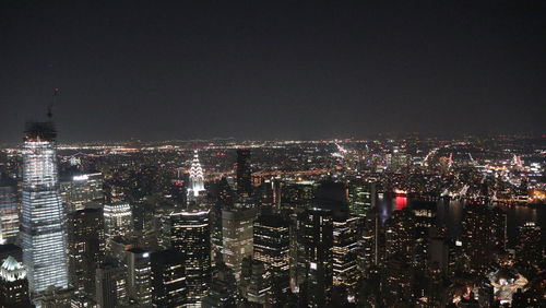 Illuminated cityscape against sky at night