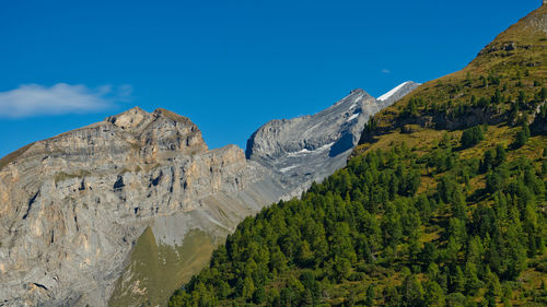 Scenic view of mountains against blue sky