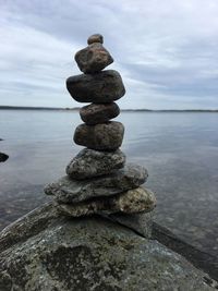 Stack of pebbles on beach against sky