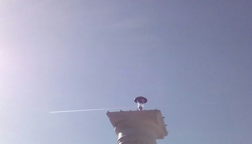 Low angle view of vapor trail against clear blue sky