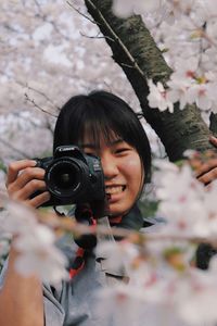 Portrait of woman photographing with camera