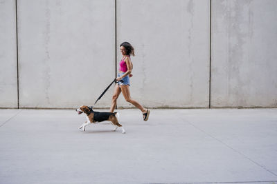 Full length of woman walking with dog